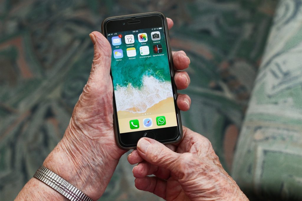 Starsza osoba ze smartfonem w dłoni